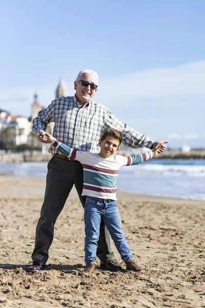 Abuelo y nieto jugando en la playa de Sitges — Foto de Stock