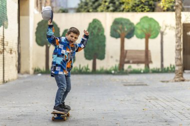 Kaykayıyla gezen coşkulu küçük çocuk.