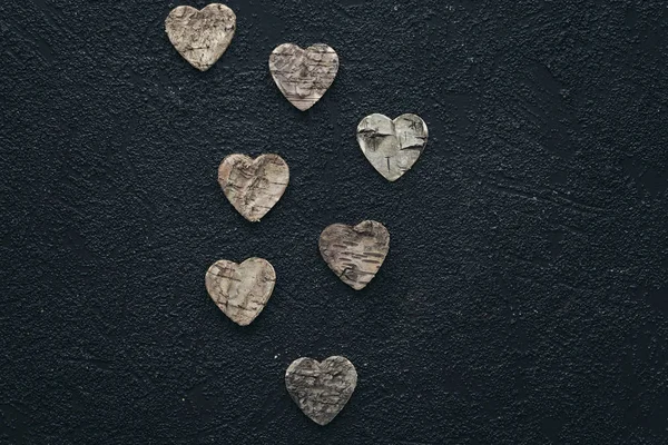 Trähjärtan på en svart bakgrund. Alla hjärtans dag koncept. — Stockfoto