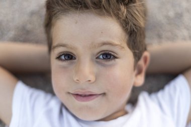 Kumsalda uzanmış sevimli bir çocuğa yaklaş.