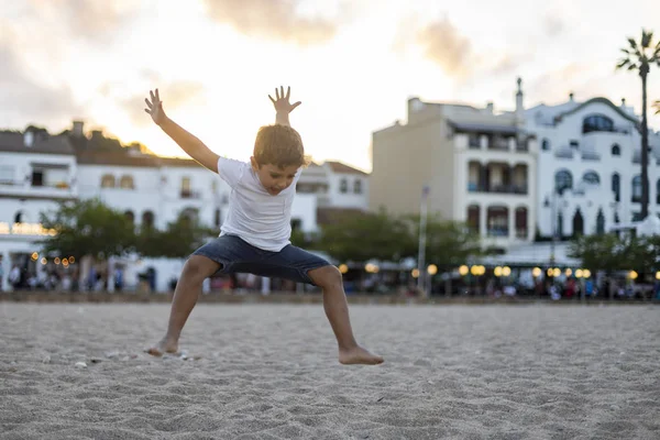 Schattiger kind spelen op het strand bij zonsondergang — Stockfoto