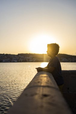 Argostoli, Yunanistan 'da gün batımını seyreden sevimli çocuk.