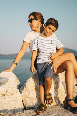 Anne ve oğul rahatça denize bakıyor.