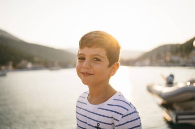 Gün batımında gülümseyen tatlı bir çocuk.