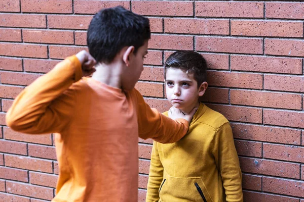 Little kid hitting another on the school. Bullying concept