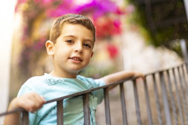 Korkuluk tutan sevimli bir çocuğun portresi