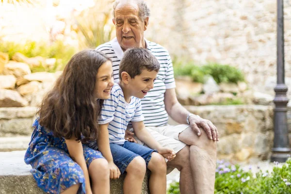 Дедушка и внуки смеются на улице — стоковое фото
