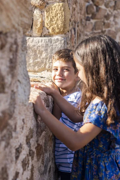 Zwei Kinder suchen werfen die Mauer einer Burg — Stockfoto