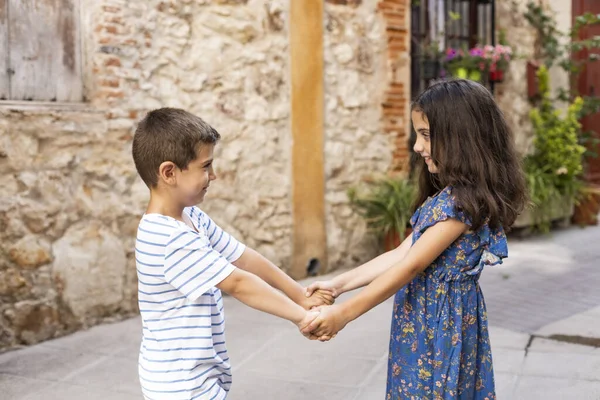 Twee kinderen die elkaars hand vasthouden op een lentedag — Stockfoto