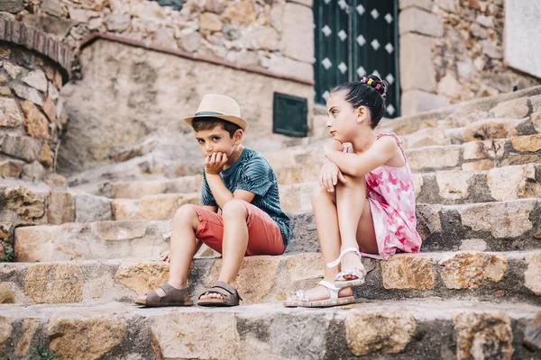 Zwei gelangweilte Kinder sitzen an einem Sommertag auf einer Treppe — Stockfoto