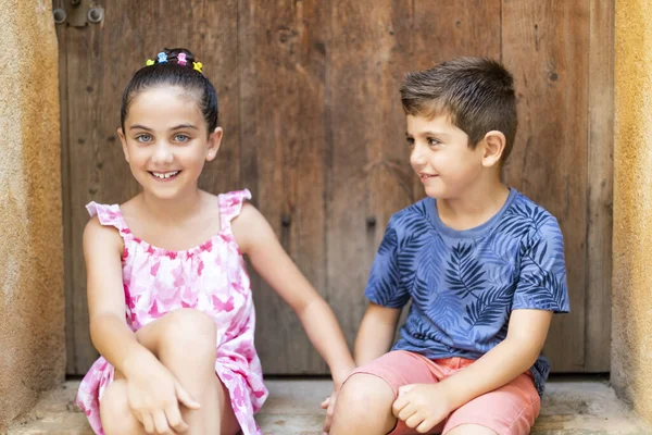 Portret van twee kinderen zittend handen vasthouden — Stockfoto