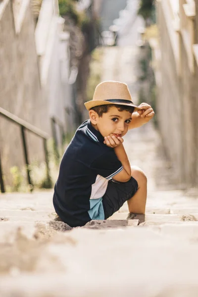 Portret van een schattige jongen met hoed op een trap — Stockfoto