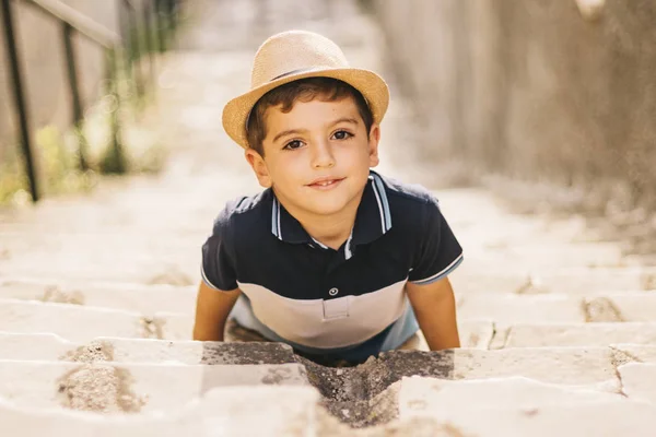 Portret van een schattige jongen met hoed op een trap — Stockfoto