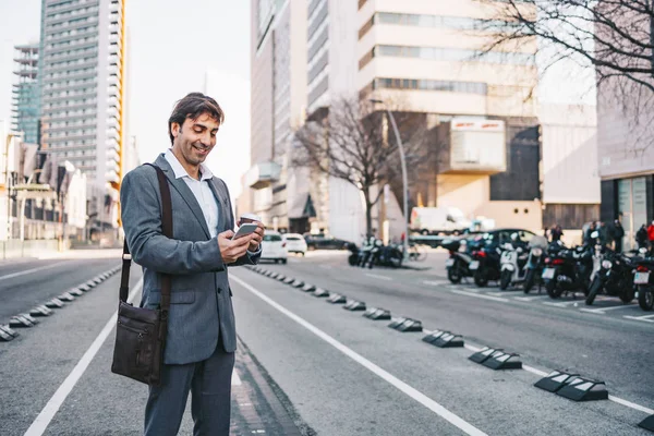 Middle aged businessman using his cellphone on the city