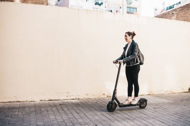 Orta yaşlı bir kadın elektrikli scooter kullanıyor.