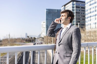 Şehirde cep telefonu kullanan mutlu bir işadamı.