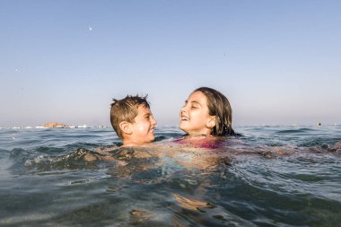 Denizde oynayan iki küçük çocuk