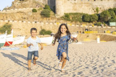 Kumsalda koşan iki küçük arkadaş