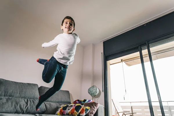 Funny kid jumping off the couch