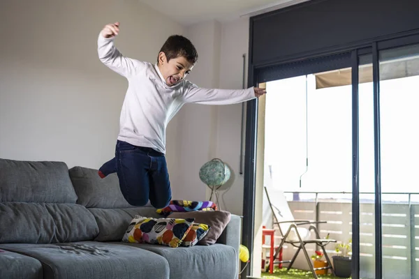 Funny kid jumping off the couch