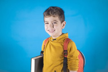 Mavi bir sırt çantalı mutlu çocuk.