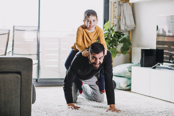 Отец и сын играют дома
