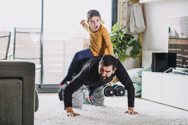 Отец и сын играют дома
