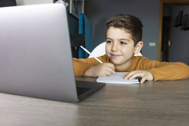 Sanal sınıftaki küçük çocuk. Okul evde.