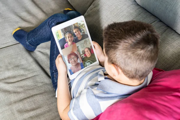 Closeup view of little kid talking with family via video chat at home