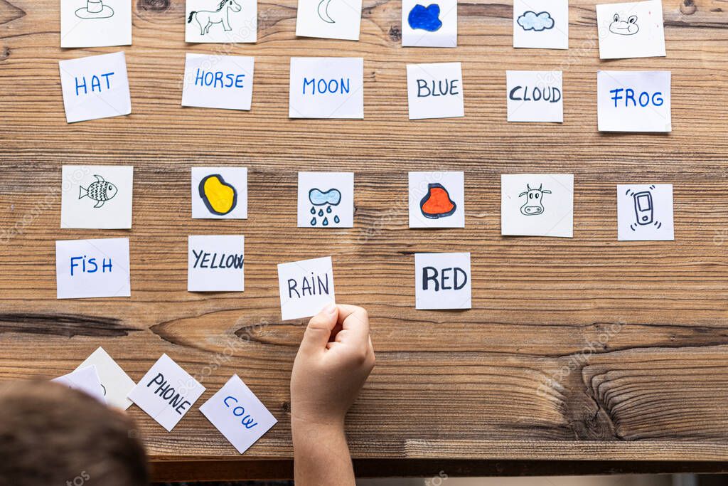 Little kid playing with cards of words and pictures. Time to learn. Education concept.