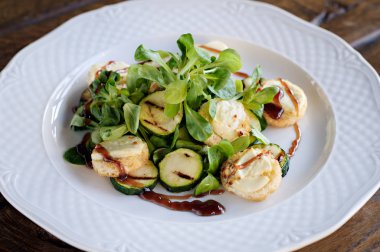 Vejetaryen salata ızgara zuchinni, ekmek, keçi peyniri, taze marul ve sos ile