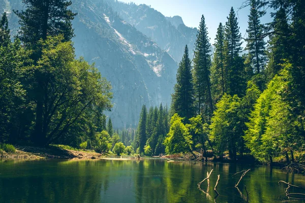 Green lake and forest with a view of Glacier Point, Yosemite National Park. National park in Sierra Nevada, mountains of Nothern California
