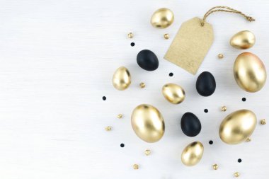 Minimal gold eggs easter concept. Stylish easter golden and black eggs with golden label for sales, promotion. Flat lay trendy easter. Happy easter card with copy space for text
