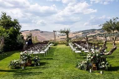 Toskana 'daki villanın arka bahçesinde okaliptüs kompozisyonları ve çiçeklerle süslenmiş ahşap kemer var.