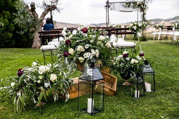 in backyard of villa in Tuscany there is ceremony wooden arch decorated with eucalyptus compositions and flowers