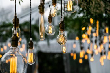 Toskana 'daki villanın arka bahçesinde bir resepsiyon alanında asılı dekoratif lambalar var.