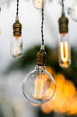 Toskana 'daki villanın arka bahçesinde bir resepsiyon alanında asılı dekoratif lambalar var.