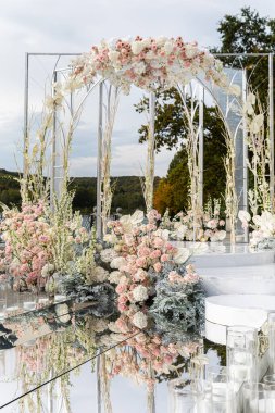 Güzel çiçeklerle kurulmuş bir düğün, açık havada.