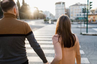 Gün doğumunda Roma 'da yürüyen bir çift. Ana odak noktası kız. Dikiz aynası. Arka planda, yol ile bulanık bir arkaplan.