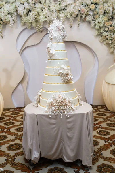 放在桌上的结婚蛋糕 在花的周围室内 — 图库照片