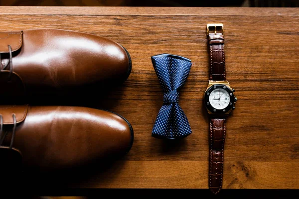 男用饰品 金戒指 手表和新郎皮鞋放在木制桌子上 商人服装细节的概念 奢侈品男人的配件 别致的男鞋 — 图库照片