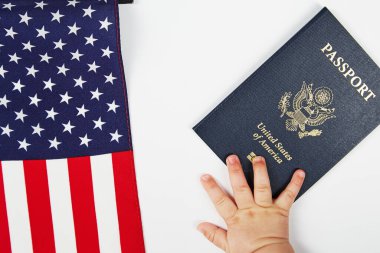 Amerikan pasaportu. Beyaz arka plan. Bebeğin eli ona uzanıyor. ABD bayrağı.
