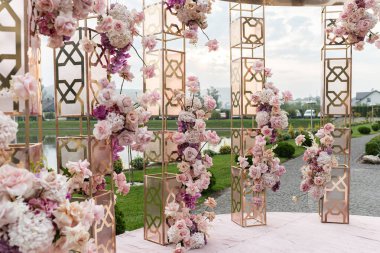 Güzel çiçeklerle kurulmuş bir düğün, açık havada. Su.