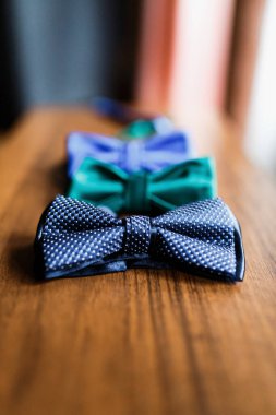 Erkek aksesuarları, parfüm, yaka çiçeği, altın yüzükler, saatler ve ahşap masadaki damadın deri ayakkabıları. İş adamı giysi detayı konsepti. Lüks erkek aksesuarları. Şık erkek ayakkabıları..