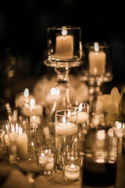 Kutlamalar için masada duran mumlar. İltihaplı. Masanın üzerindeki çatal bıçak takımının düzenini görebilirsiniz..