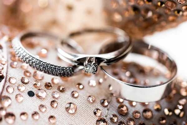 ウェディングリング花嫁と新郎のための貴重な石を持つ金の指輪光沢のあるラインストーンの背景にクローズアップ ガーナの鉄砲水 — ストック写真