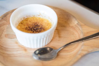 Creme Brulee, olarak da bilinen yanık krema, bir tatlı zengin muhallebi temel ve karamel, ahşap plaka üzerinde tarafından tepesinde ile