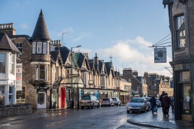 Pitlochry, İngiltere - 10 Kasım 2017: nehir Tummel yalan Pitlochry, Perthshire İlçesi İskoçya'da bir burgh ana cadde üzerinde yürüyen insanlar