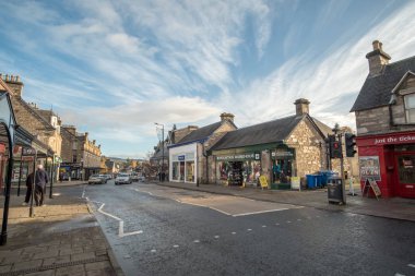 Pitlochry, İngiltere - 10 Kasım 2017: nehir Tummel yalan Pitlochry, Perthshire İlçesi İskoçya'da bir burgh ana cadde üzerinde yürüyen insanlar