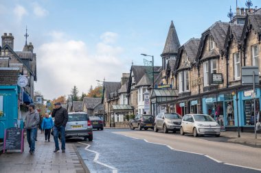 Pitlochry, İngiltere - 10 Kasım 2017: nehir Tummel yalan Pitlochry, Perthshire İlçesi İskoçya'da bir burgh ana cadde üzerinde yürüyen insanlar